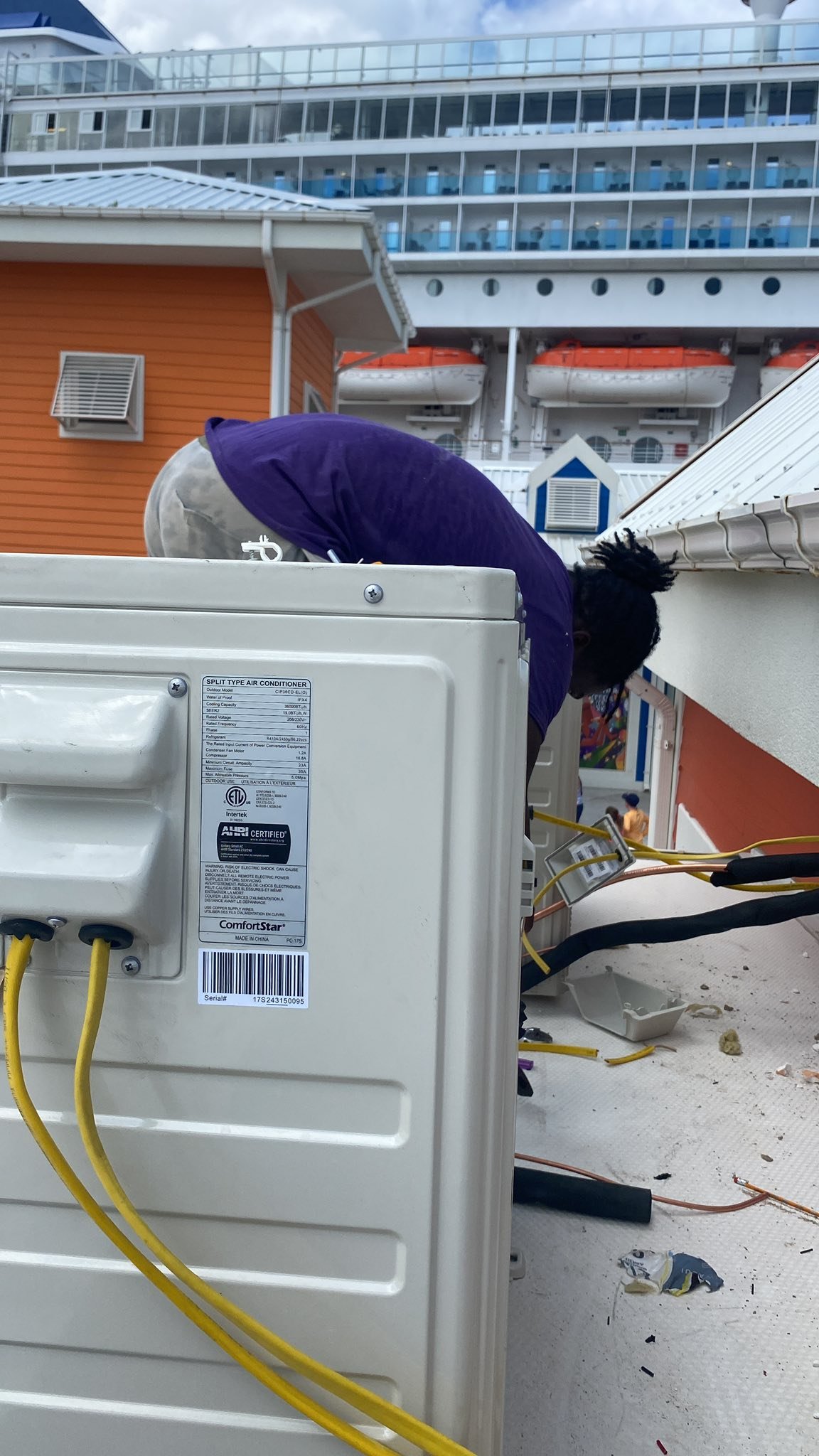 Technician installing AC outdoor unit at Nassau Cruise Port
